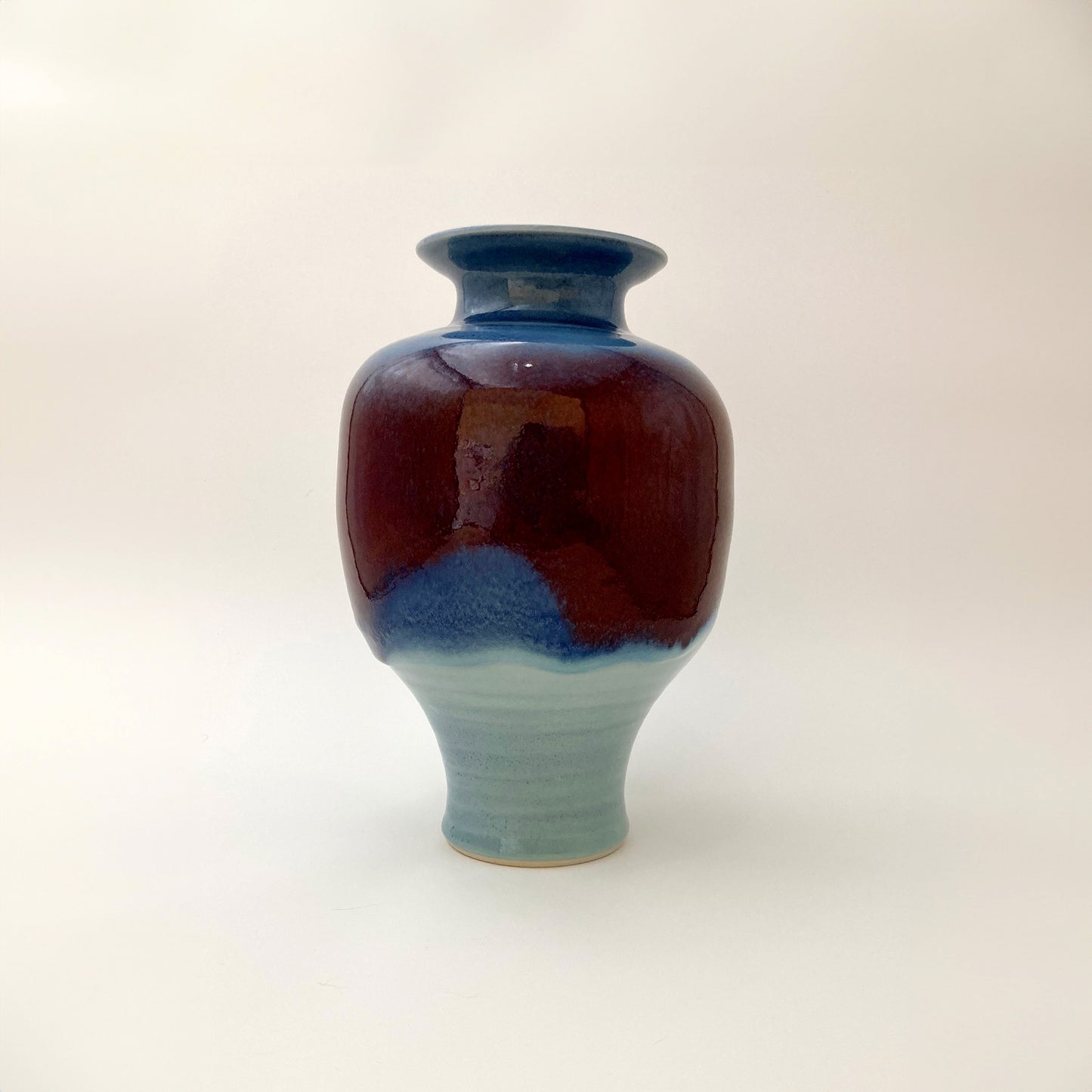 Ceramic vase with two-tone blue and red design on a white background