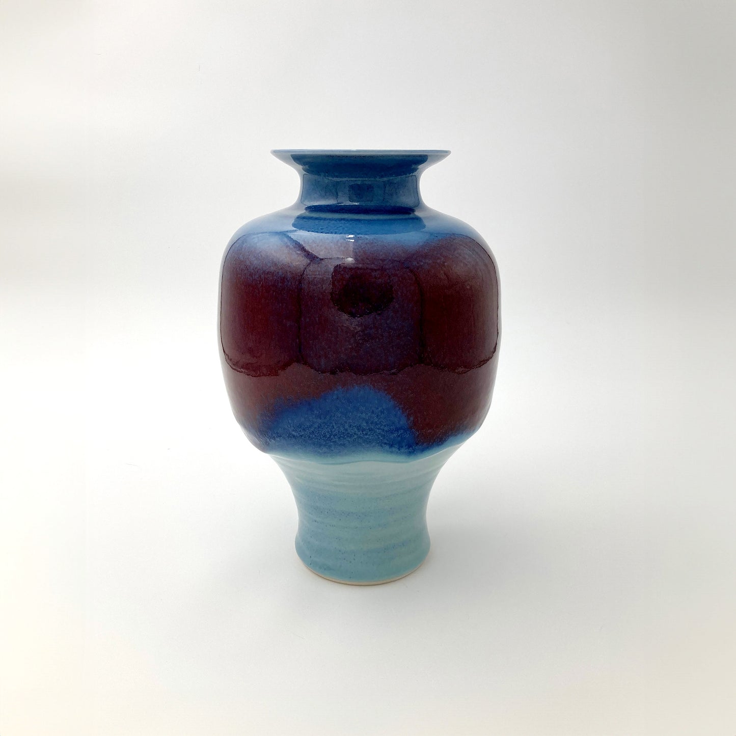 Ceramic vase with blue and red gradient on a white background