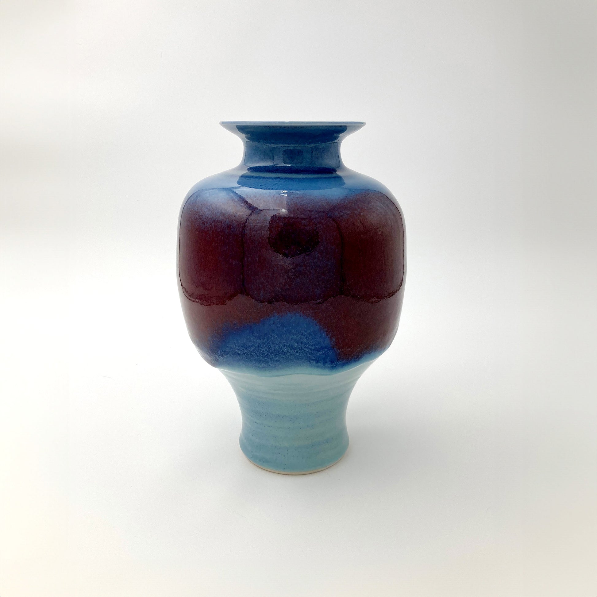 Ceramic vase with blue and red gradient on a white background