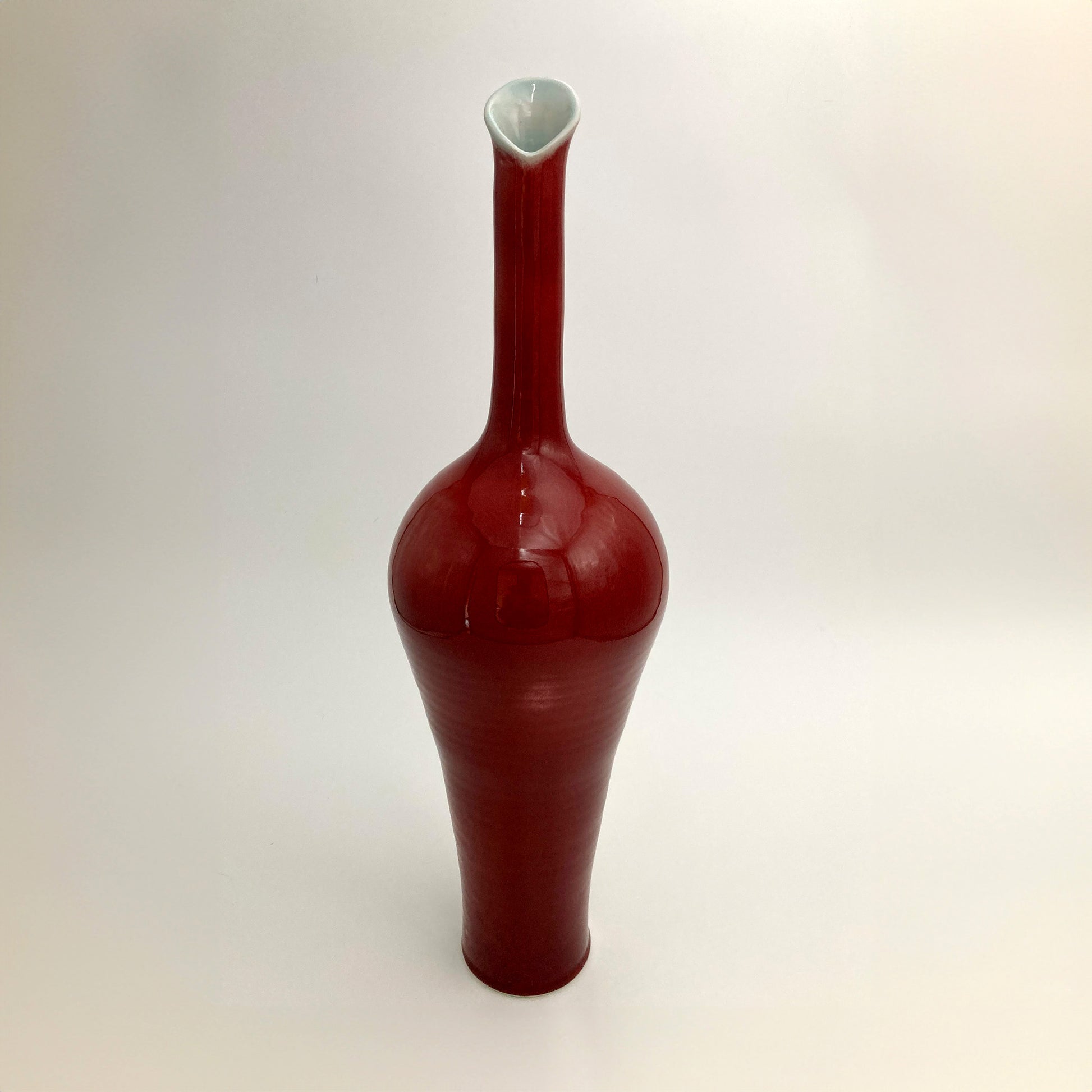 Red ceramic vase celadon rim on a white background