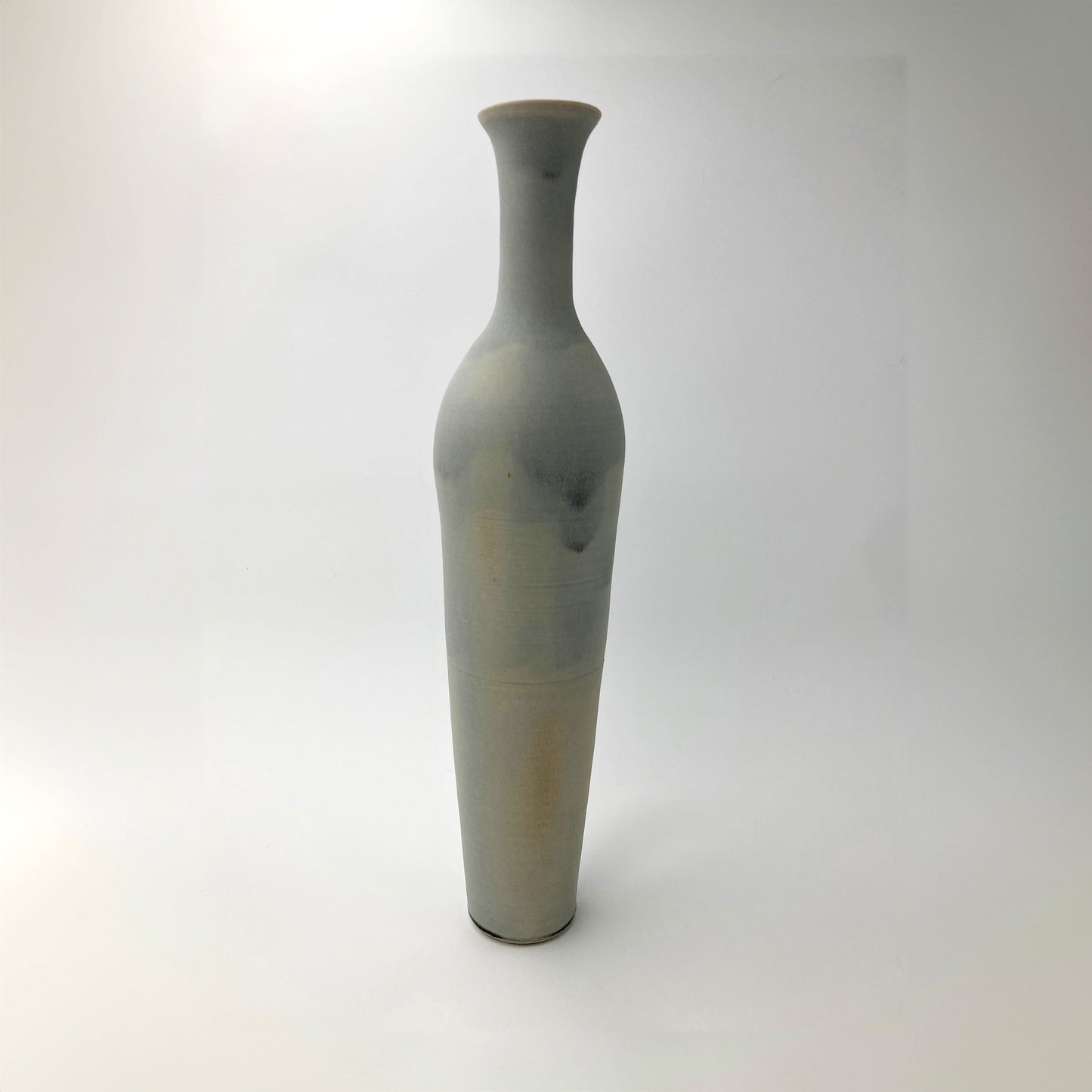 Tall celadon gray ceramic vase on a white background