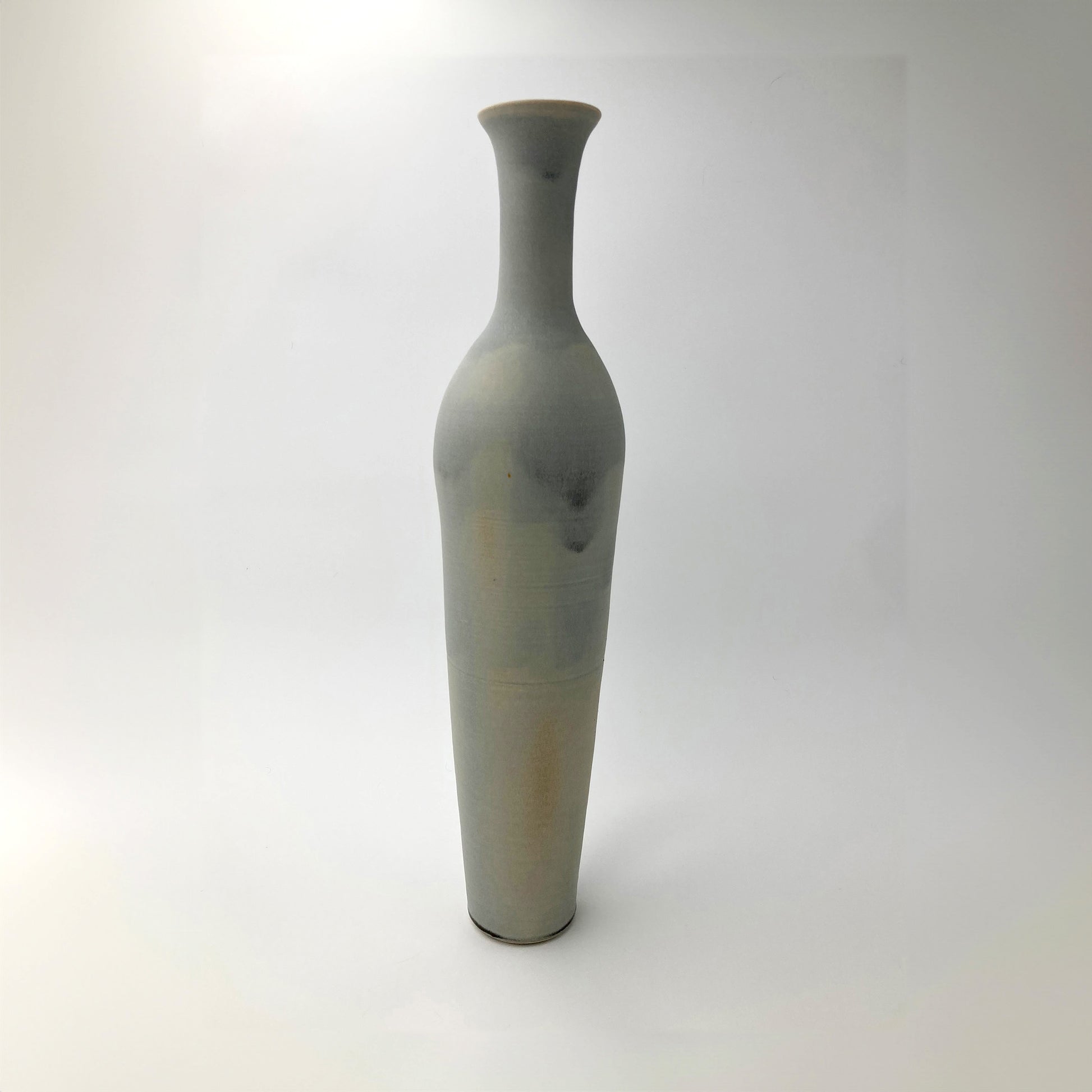 Tall celadon gray ceramic vase on a white background