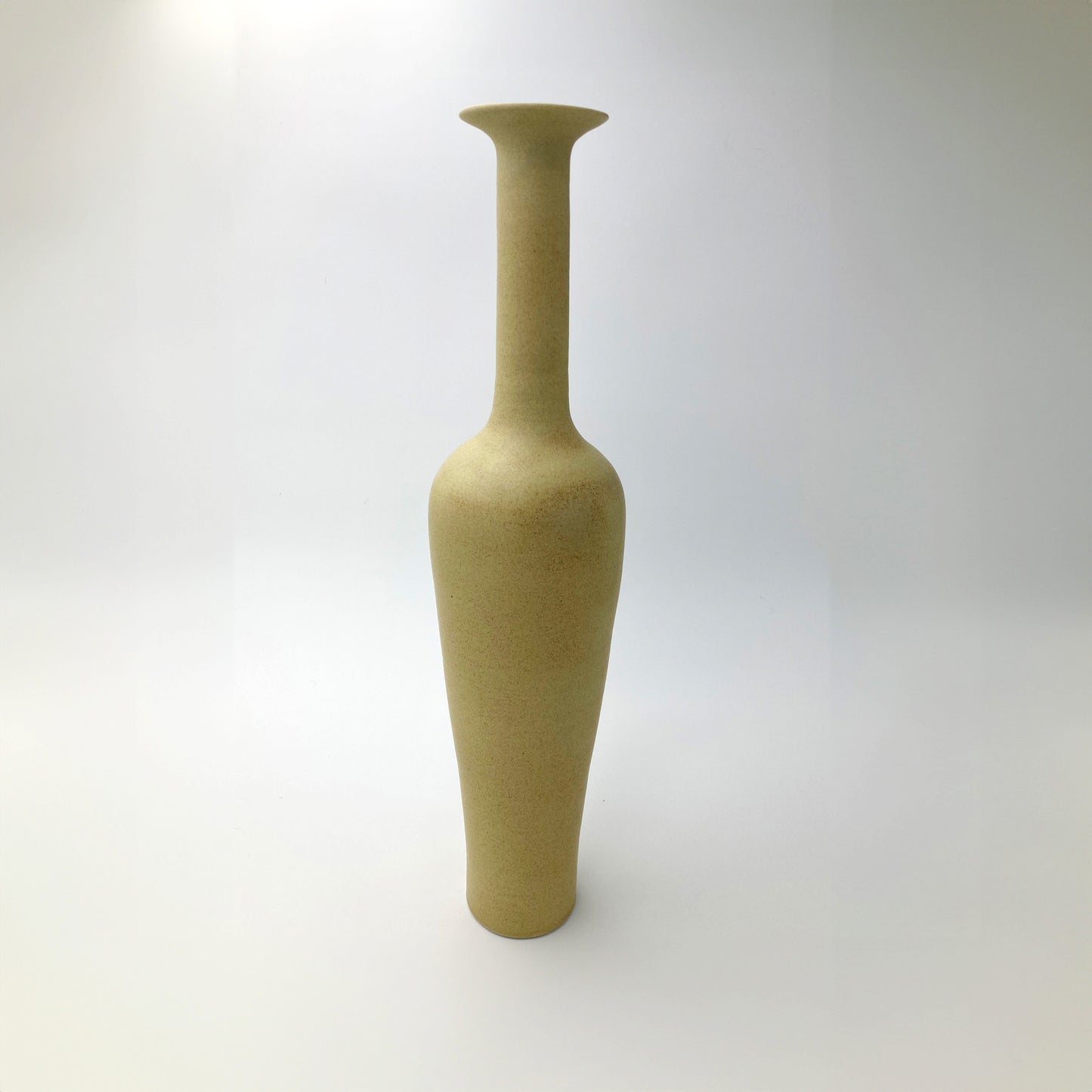 Golden ochre ceramic vase on a white background