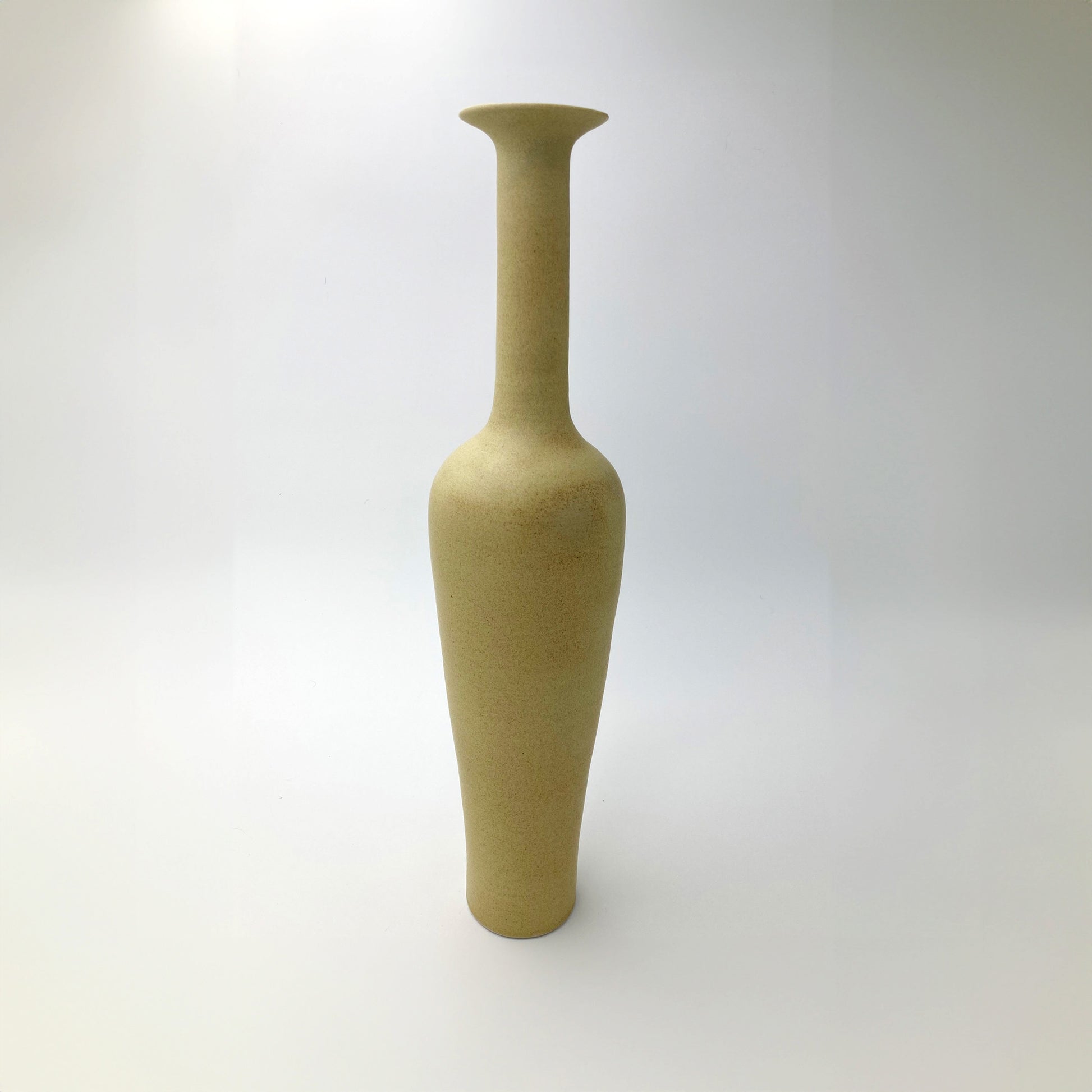 Golden ochre ceramic vase on a white background