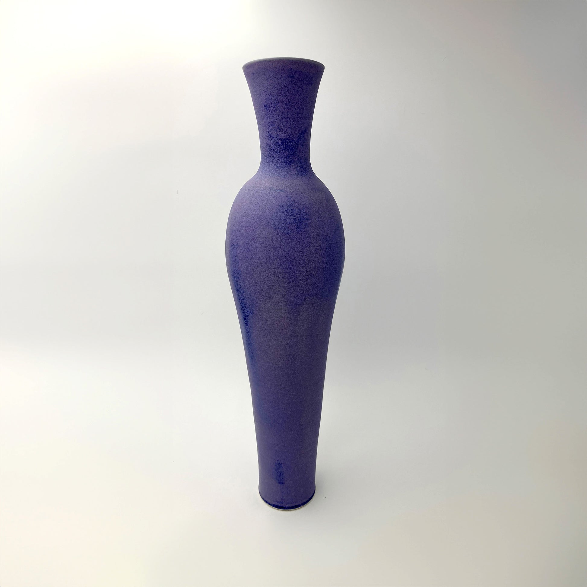 Tall purple vase on a white background